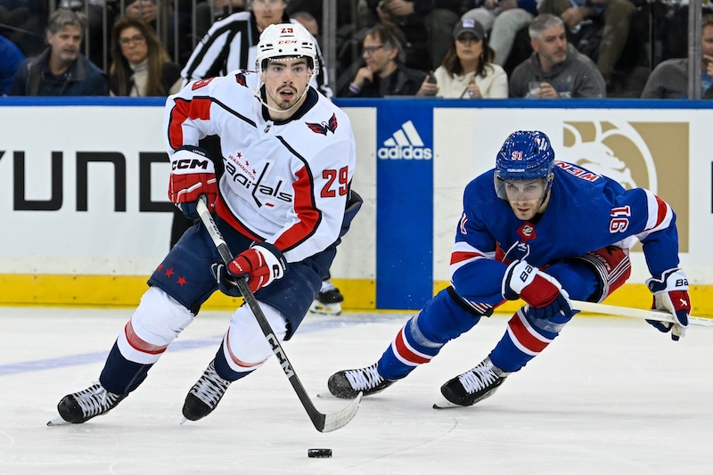 Washington Capitals center Hendrix Lapierre (29) skates with the puck chased by New York Rangers center Alex Wennberg (91) during the second period in game two of the first round of the 2024 Stanley Cup Playoffs at Madison Square Garden.