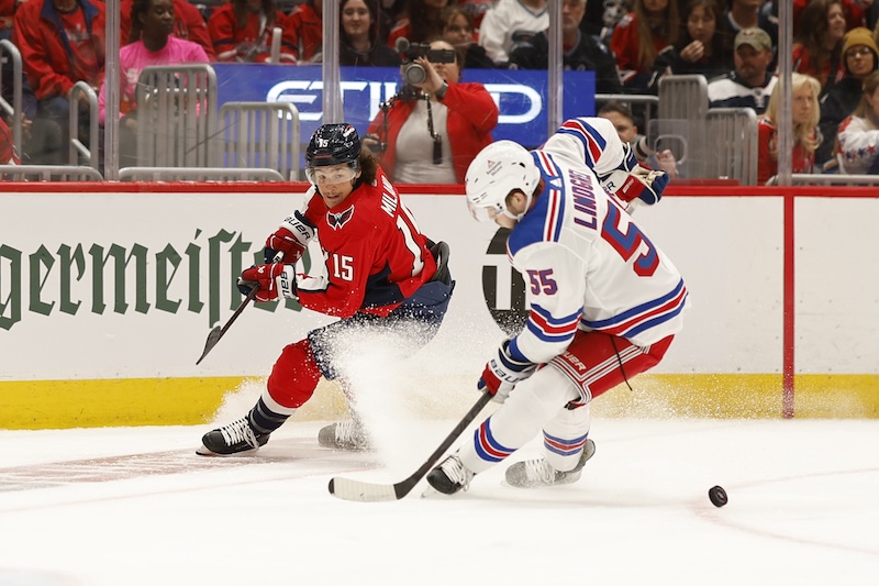 New York Rangers defenseman Ryan Lindgren (55) and Washington Capitals left wing Sonny Milano (15) battle for the puck in the first period in game three of the first round of the 2024 Stanley Cup Playoffs at Capital One Arena.