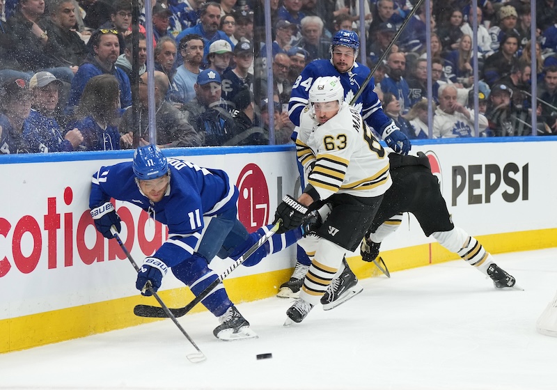 Boston Bruins left wing Brad Marchand (63) battles for the puck with Toronto Maple Leafs center Max Domi (11) during the first period in game four of the first round of the 2024 Stanley Cup Playoffs at Scotiabank Arena.