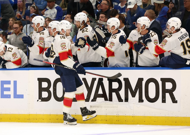 Florida Panthers center Steven Lorentz (18) is congratulated by center Kevin Stenlund (82), center Anton Lundell (15) and teammates after he scored a goal against the Tampa Bay Lightning during the third period in game three of the first round of the 2024 Stanley Cup Playoffs at Amalie Arena.