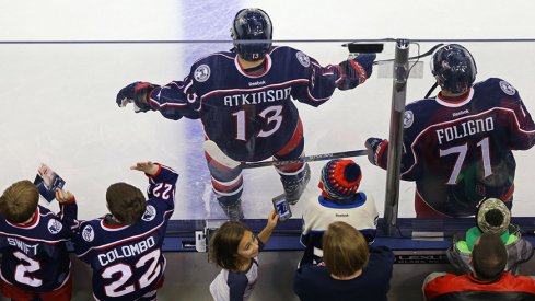 Fans stand behind Cam Atkinson and Nick Foligno of the Columbus Blue Jackets.