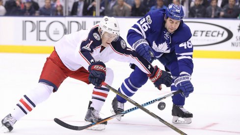 Columbus Blue Jackets left wing Matt Calvert (11) reaches for the puck as Toronto Maple Leafs defenseman Roman Polak (46) goes after the puck at Air Canada Centre.