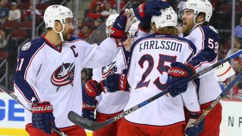 Multiple Blue Jackets including William Karlsson celebrate after scoring a goal