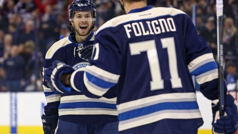 Oliver Bjorkstrand and Nick Foligno celebrate after scoring a goal.