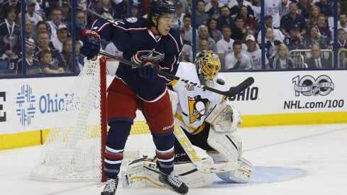 Sonny Milano sits in front of the Penguins net as he tries to deflect the puck