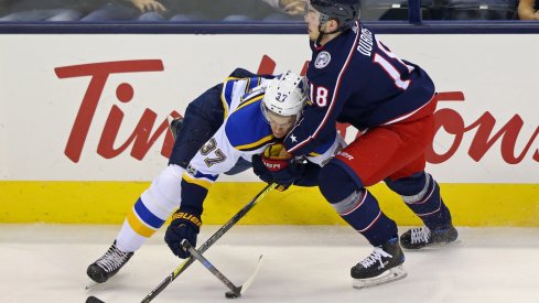 Pierre-Luc Dubois forces a St. Louis Blues player off of the puck