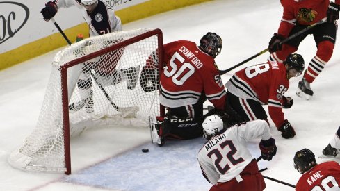 Sonny Milano eyes the puck before he pushes it across the line for a goal against the Chicago Blackhawks