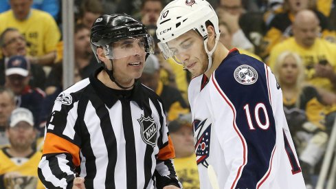 A referee yells at Alexander Wennberg during a preseason game in Pittsburgh