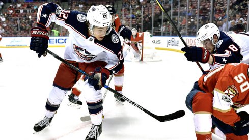 Sonny Milano retrieves a puck against the Florida Panthers