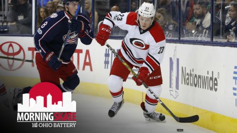 Hurricanes Brock McGinn tries to skate away from Zach Werenski of the Columbus Blue Jackets