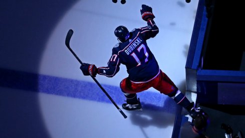 Brandon Dubinsky knocks pucks onto the ice during warm ups