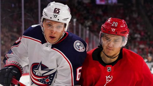 Markus Nutivaara and Sebastian Aho battle for a puck in Carolina.