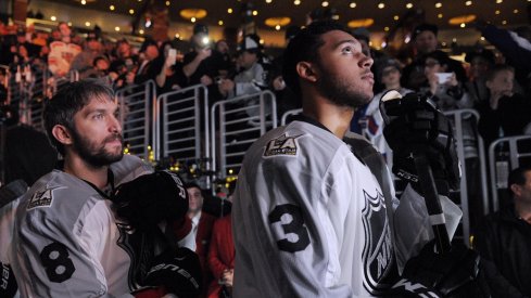 Seth Jones waits to take the ice with Alex Ovechkin right behind him