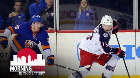 Cam Atkinson attempts to skate away from an Islanders defenseman