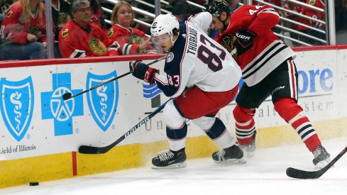 Blue Jackets prospect Calvin Thurkauf battles for a loose puck during preseason action against the Chicago Blackhawks.