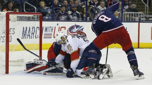 Zach Werenski tries to clear the puck against the Florida Panthers