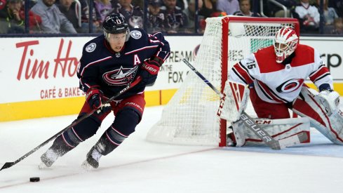 Curtis McElhinney tracks Cam Atkinson as he skates with the puck for the Columbus Blue Jackets.