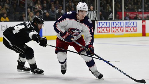 Zach Werenski skates with the puck against the Los Angeles Kings 