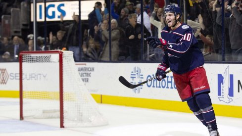 Alexander Wennberg celebrates his first goal of the season by pointing at Seth Jones, who set him up.