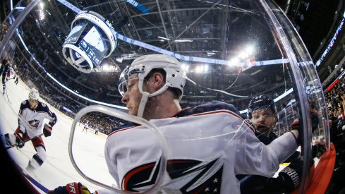 Pierre-Luc Dubois looks on as Artemi Panarin plays the puck