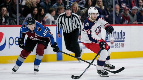 Oliver Bjorkstrand possesses the puck in front of Colorado Avalanche center Nathan MacKinnon at the Pepsi Center