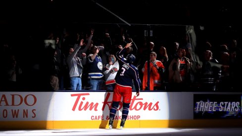 Seth Jones gives a fan a stick after the Blue Jackets overtime win