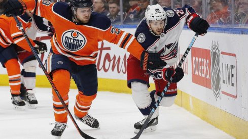 Edmonton Oilers forward Leon Draisaitl (29) and Columbus Blue Jackets forward Oliver Bjorkstrand (28) battle for a loose puck during the second period at Rogers Place.