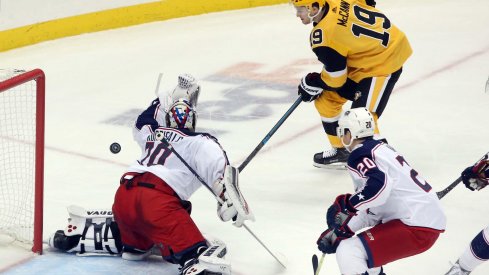 Columbus Blue Jackets goaltender Joonas Korpisalo (70) makes a save against Pittsburgh Penguins center Jared McCann (19) during the second period at PPG PAINTS Arena.