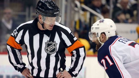 NHL referee Kelly Sutherland (11) talks with Columbus Blue Jackets left wing Nick Foligno (71) against the Pittsburgh Penguins during the third period at PPG PAINTS Arena. The Penguins shutout the Blue Jackets 3-0.