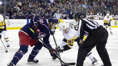 Pittsburgh Penguins center Sidney Crosby (87) and Columbus Blue Jackets center Alexander Wennberg (10) face-off during the first period at Nationwide Arena.