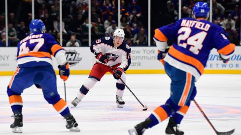 Columbus Blue Jackets center Ryan Dzingel (19) skates with the puck while being defended by New York Islanders right wing Leo Komarov (47) and defenseman Scott Mayfield (24) during the first period at Nassau Veterans Memorial Coliseum.