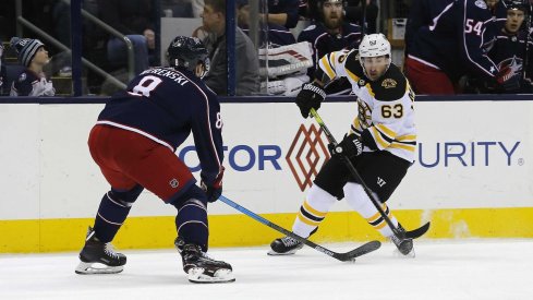 Zach Werenski takes the puck away from Brad Marchand in a victory over the Boston Bruins on Tuesday night.