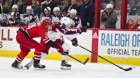 Artemi Panarin attempts to skate by Hurricanes defenseman Jaccob Slavin