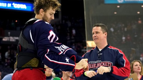 Hockey fan Doug Vance receives the jersey off the back of Columbus Blue Jackets center Alexander Wennberg (10) after a game against the Carolina Hurricanes at Nationwide Arena.