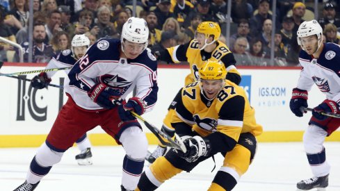 Columbus Blue Jackets forward Alexandre Texier battles with Pittsburgh Penguins forward Sydney Crosby during the Penguins' home opener for the 2019 NHL Regular Season. 