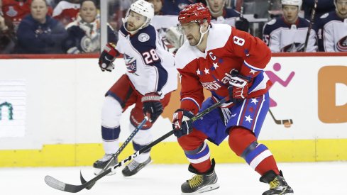 Columbus Blue Jackets forward Oliver Bjorkstrand fights for the puck against Alexander Ovechkin of the Washington Capitals.