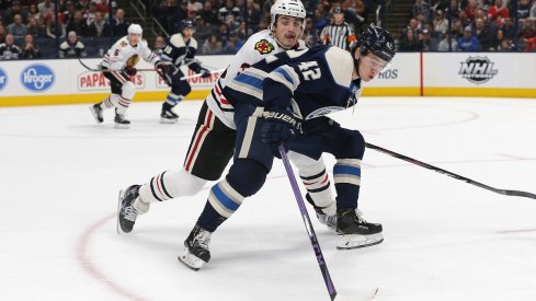 Dennis Gilbert attempts to steal the puck from Alexandre Texier 