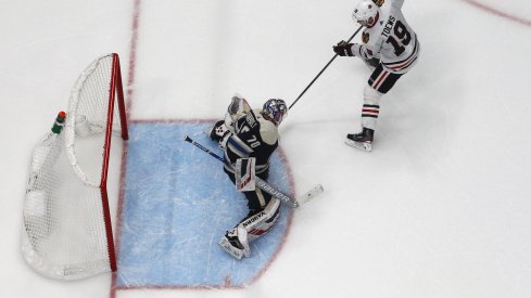 Dec 29, 2019; Columbus, Ohio, USA; Chicago Blackhawks center Jonathan Toews (19) slides the puck under Columbus Blue Jackets goalie Joonas Korpisalo (70) for goal during the shootout at Nationwide Arena. Mandatory Credit: Russell LaBounty-USA TODAY Sports