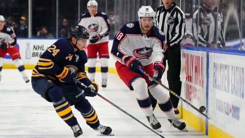 Mar 31, 2019; Buffalo, NY, USA; Buffalo Sabres defenseman Lawrence Pilut (24) and Columbus Blue Jackets center Pierre-Luc Dubois (18) go after a loose puck during the first period at KeyBank Center. Mandatory Credit: Kevin Hoffman-USA TODAY Sports