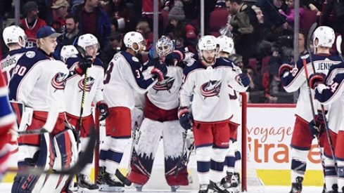 The Columbus Blue Jackets surround goaltender Elvis Merzlikins after a win over the Montreal Canadiens at the Bell Centre.