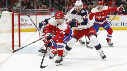 Columbus Blue Jackets defenseman Dean Kukan defends against Brendan Leipsic of the Washington Capitals.