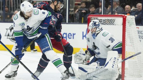 Mar 1, 2020; Columbus, Ohio, USA; Columbus Blue Jackets left wing Nick Foligno (71) takes a shot on Vancouver Canucks goaltender Louis Domingue (30) as defenseman Christopher Tanev (8) defends during the second period at Nationwide Arena. Mandatory Credit: Greg Bartram-USA TODAY Sports