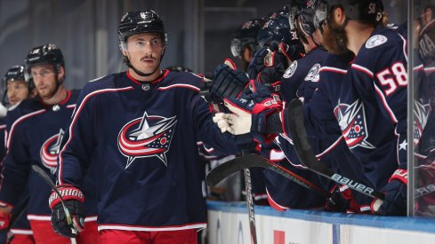 Zach Werenski #8 of the Columbus Blue Jackets skates by the bench to celebrate with teammates after Werenski scored a goal during the first period of an exhibition game against the Boston Bruins prior to the 2020 NHL Stanley Cup Playoffs at Scotiabank Arena on July 30, 2020 in Toronto, Ontario.