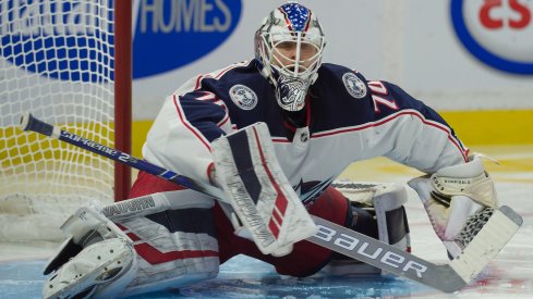 Columbus Blue Jackets goaltender Joonas Korpisalo stretches between stoppages in play.