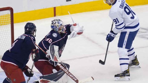 ug 7, 2020; Toronto, Ontario, CAN; Columbus Blue Jackets goaltender Elvis Merzlikins (90) makes a glove save as Toronto Maple Leafs forward John Tavares (91) looks on during the second period of game four of the Eastern Conference qualifications at Scotiabank Arena.