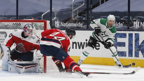 Feb 2, 2021; Columbus, Ohio, USA; Dallas Stars center Andrew Cogliano (11) passes the puck over the outstretched stick of Columbus Blue Jackets defenseman Vladislav Gavrikov (44) during the second period at Nationwide Arena.