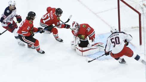 Chicago Blackhawks goaltender Kevin Lankinen (32) makes a save on Columbus Blue Jackets left wing Eric Robinson (50) during the third period at United Center.