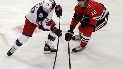 Chicago Blackhawks defenseman Nikita Zadorov battles for the puck against Columbus Blue Jackets center Riley Nash.