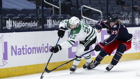 Patrik Laine fights for the puck with Esa Lindell