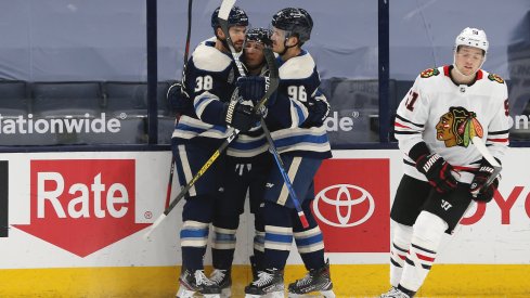 Columbus Blue Jackets forwards Jack Roslovic, Cam Atkinson, and Boone Jenner celebrate a goal scored against the Chicago Blackhawks at Nationwide Arena.